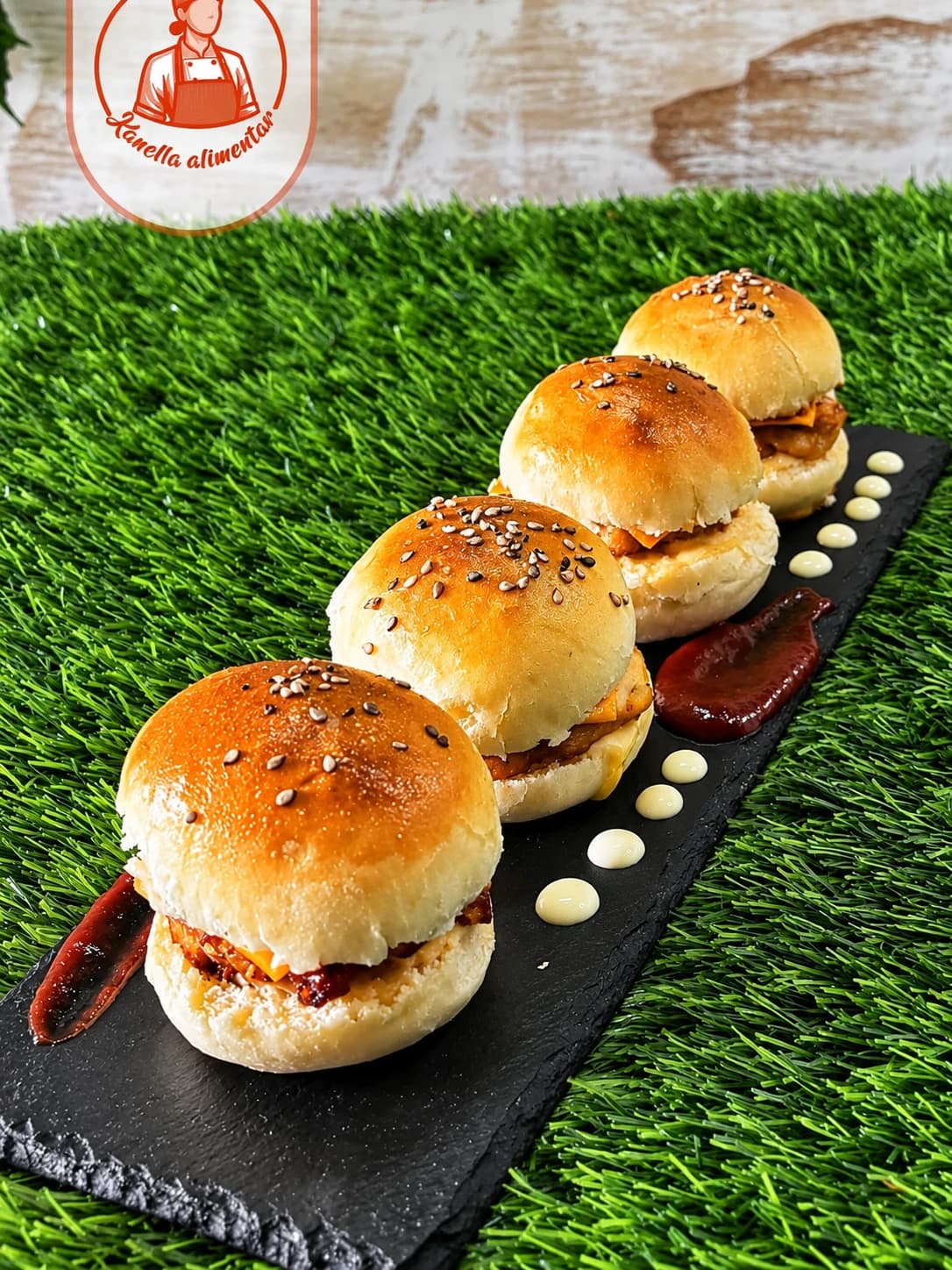 Mini hambúrgueres em pão com sésamo, servidos numa ardósia com molhos